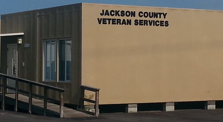 One story brown building with Veterans Services on the side