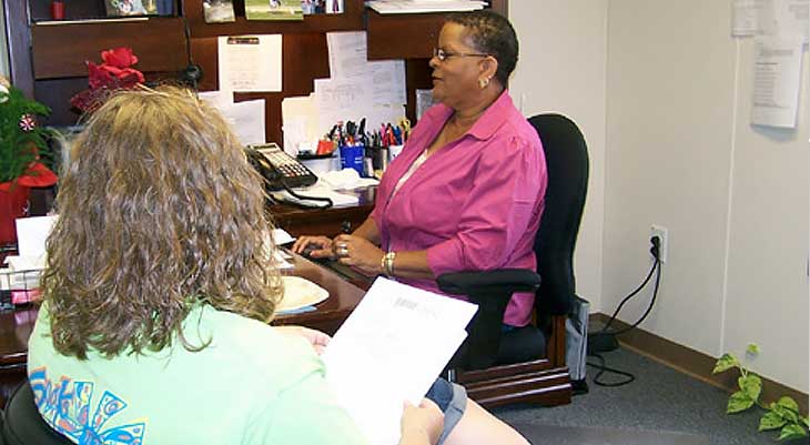 Woman behind desk with other woman