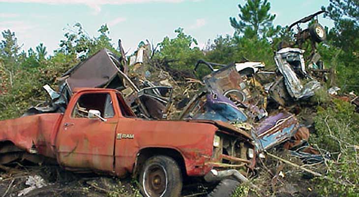 Image of decrepit truck and garbage in woods